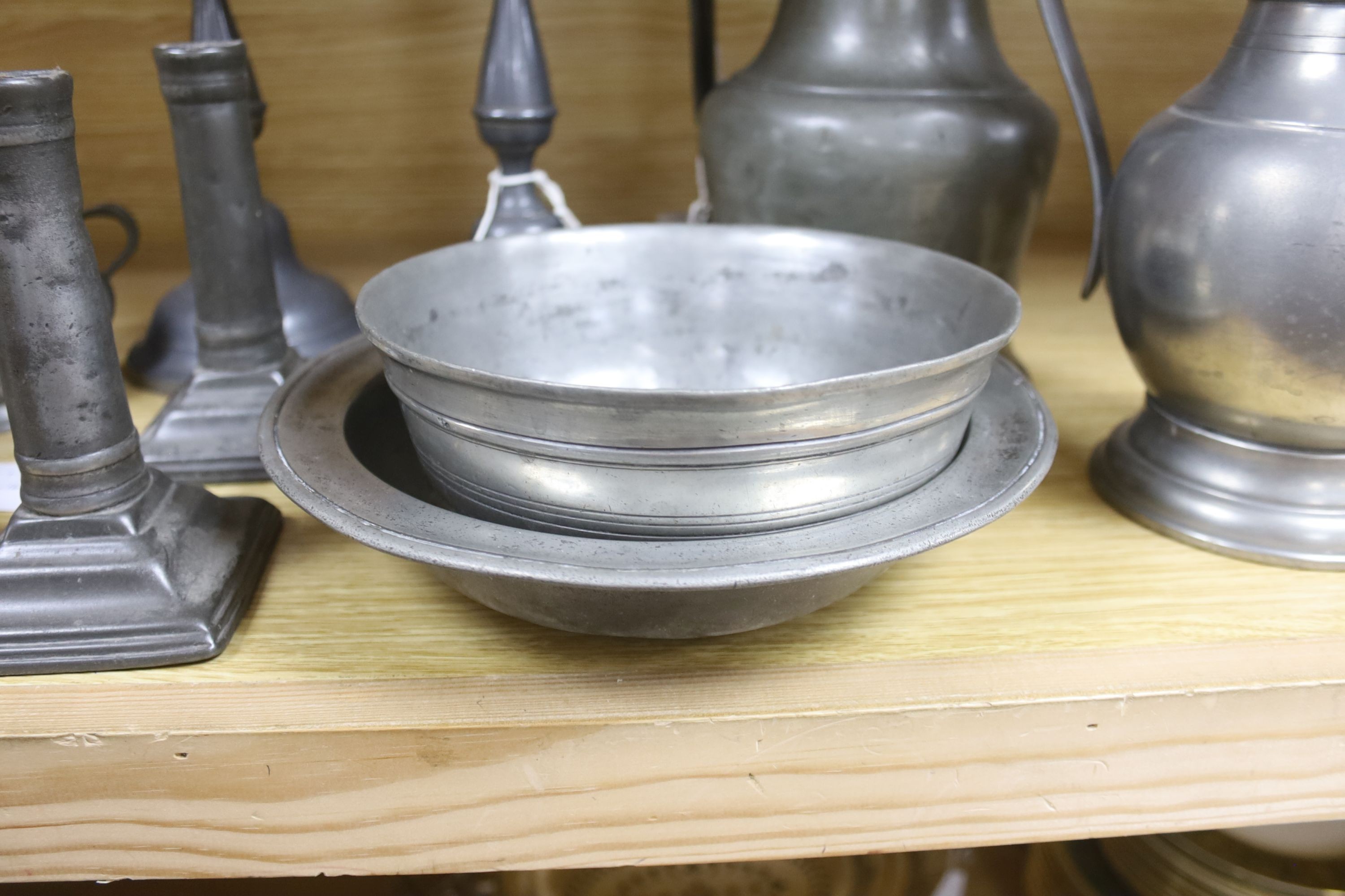 A French lidded pewter jug with double acorn thumbpiece, two pairs of pewter candlesticks and nine other items of pewter (14)